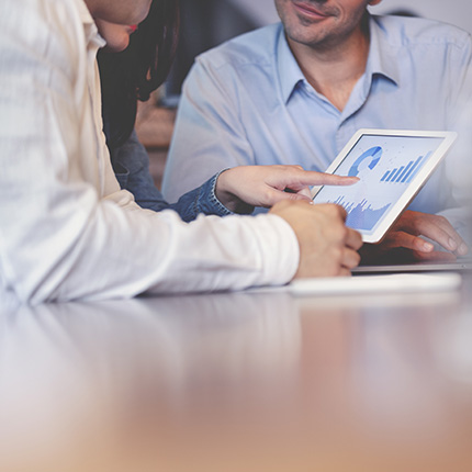 People looking at reports and charts on a tablet