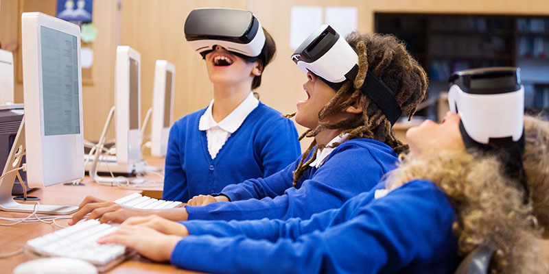 Kids playing with virtual reality headsets in a computer lab